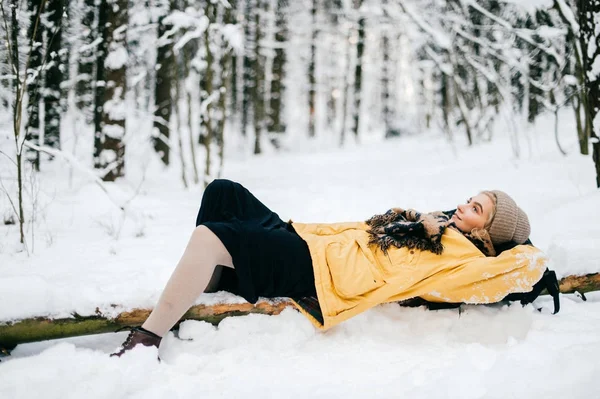 Mulher estranha bizarra deitada na árvore na floresta de inverno nevada. Menina bonita adorável relaxante ao ar livre. Mulher incomum em férias descansando na natureza. Senhora solitária viajando no frio geada dia do tempo. — Fotografia de Stock