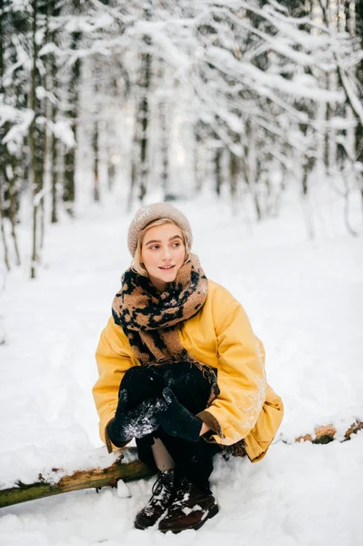 Zvláštní bizarní samice ležící na stromě ve sněhobílém zimním lese. Krásná mladá krásná dívka relaxační venku. Neobvyklá žena na dovolené odpočívající v přírodě. Osamělá dáma cestuje v mrazivém chladném dni. — Stock fotografie