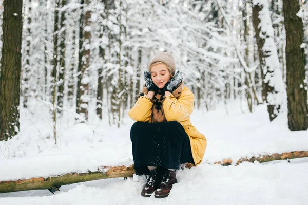 Mulher estranha bizarra deitada na árvore na floresta de inverno nevada. Menina bonita adorável relaxante ao ar livre. Mulher incomum em férias descansando na natureza. Senhora solitária viajando no frio geada dia do tempo. — Fotografia de Stock