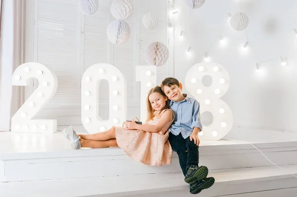 Kids in love. Handsome boy and beautiful little princess hugging each other. 2018 New Year. Lovely emotional sincere children in new yaer decorations. Celebrating winter holidays. Christmas mood. — Stock Photo, Image