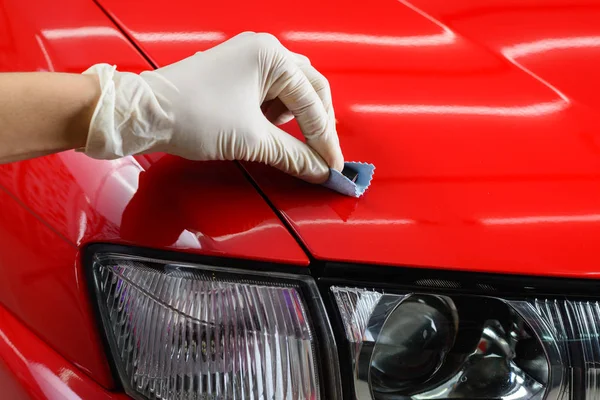 Car detailing series: Closeup of hand coating red car bonnet — Stock Photo, Image