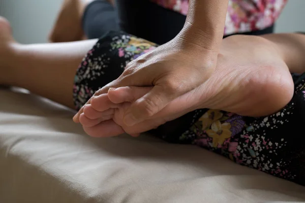 Массаж: терапевт массирует ноги и ноги азиатской женщины — стоковое фото