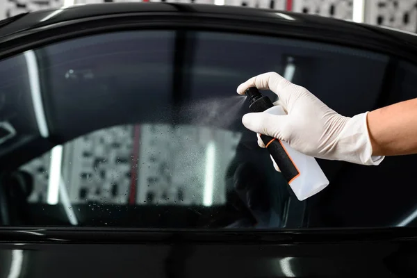 Car detailing series: Hand spraying window cleaner on car windo