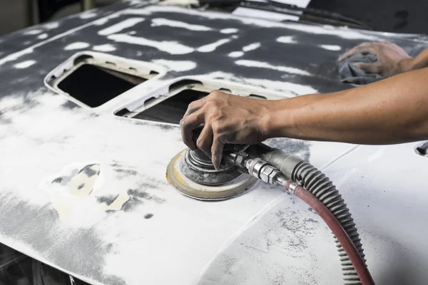 Serie zur Karosseriereparatur: Mechaniker schleift Motorhaube — Stockfoto