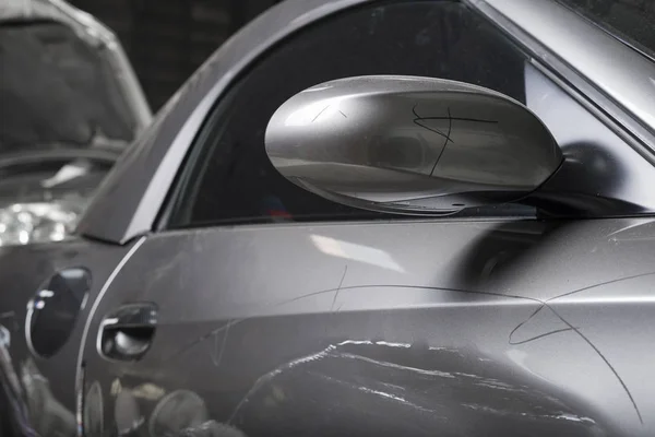 Серія ремонту автомобілів: крупним планом пошкоджений сірий спортивний автомобіль з подряпинами — стокове фото