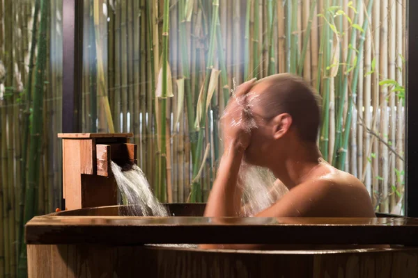 Onsen serii: Asian Mężczyzna mycia twarzy w drewnianą wannę — Zdjęcie stockowe