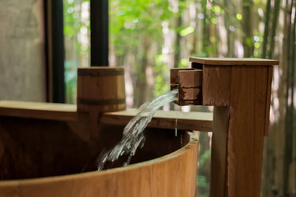 Серия Onsen: Вода, льющаяся в деревянную ванну — стоковое фото