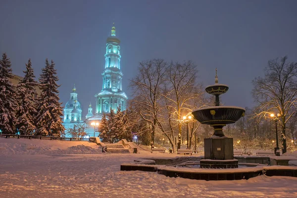 Varsayım katedrali ve çeşme kış akşamı parkta. Kharkiv, Ukrayna