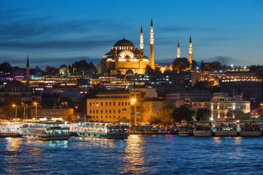 ISTANBUL, TURKEY - October 10th, 2019: View to Eminonu pier and Suleymaniye mosque across the Bay of Golden Horn after sunset