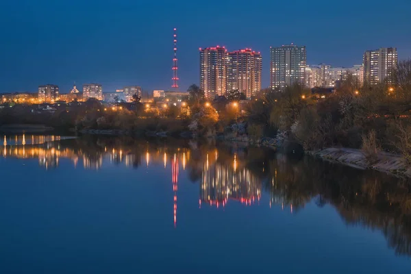 Urban landscape, view to residential quarters reflecting in calm water. Kharkiv, Ukraine