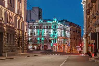 KHARKIV, UKRAINE - 21 Nisan 2020: Alacakaranlıktaki şehrin merkezindeki boş sokak ve tarihi binalara bakın