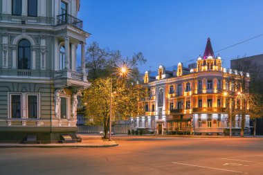 KHARKIV, UKRAINE - 21 Nisan 2020: Alacakaranlıktaki şehrin merkezindeki boş sokak ve tarihi binalara bakın