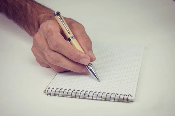Мужская рука с ручкой на блокноте . — стоковое фото