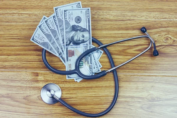 Stethoscoop op een stapel geld — Stockfoto