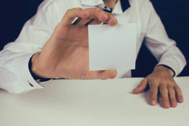 bir kağıt parçası tutan adam