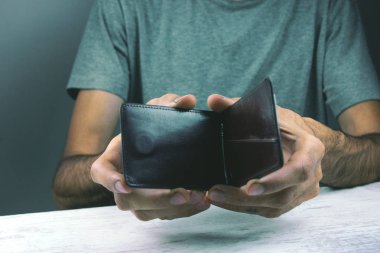 Genç adam boş cüzdan tutuyor.