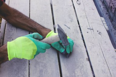 İşçi tahtaya çivi çakıyor.