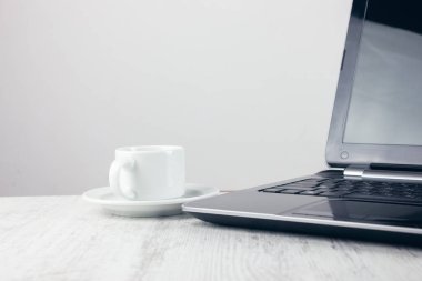 computer with a white cup on the table
