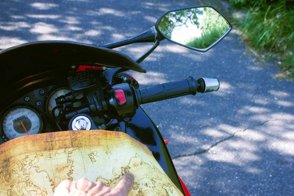 Motorcyclist holds in hand a map and looks at the map — Stok fotoğraf