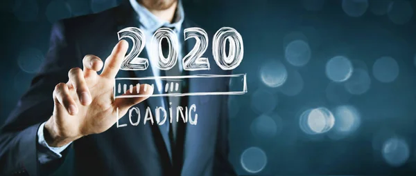 Affärsman klickar på skärmen med text lastning 2020 — Stockfoto