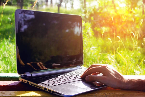 Hombre trabaja con una computadora al aire libre — Foto de Stock