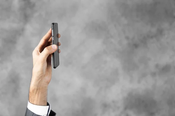 Hombre de negocios muestra el teléfono en su mano — Foto de Stock