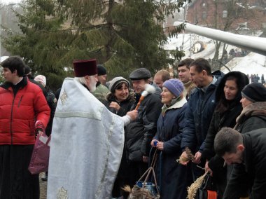 Kharkov, Ukrayna - 19 Ocak 2013: Din adamları aspirasyon Avrupa Birliği'nde. Tapınağın kutsal kişilerin resmi anne Tanrı rahip cemaat Epiphany üzerinde sanctifies. Rahip çanta üzerinde Londra bulunmakta. 2016 yılında İngiltere AB çekilme duyurdu..