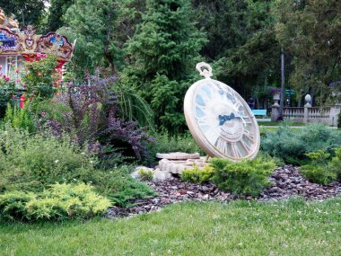 Gizli semboller. Fırsat penceresi. Kocaman bir saatin sağında bir erkek silueti var. Arkasında işaretler var. Saatin sol tarafında dönen bir atlıkarınca (zamanı değiştirmenin sembolü) ve açık bir pencere bulunur..