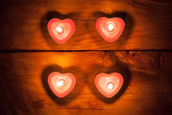Valentijnsdag harten kaarsen houten achtergrond — Stockfoto