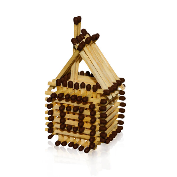 игрушечный домик из спичек на белом фоне
