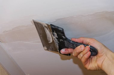 The hand of the employee to use stucco on the ceiling joints clipart