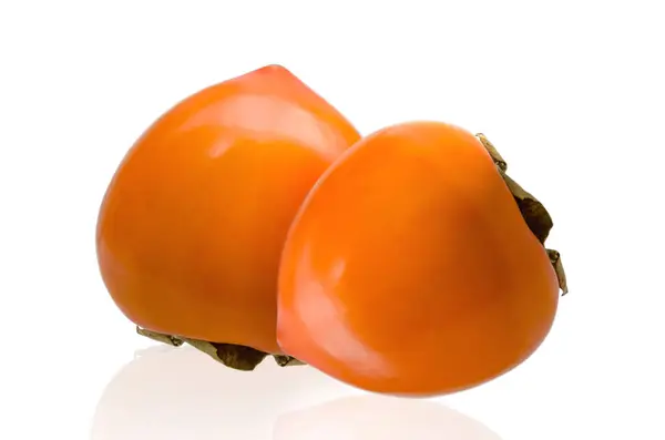 Dwie dojrzałe persimmon owoce na białym tle. Ścieżki przycinające — Zdjęcie stockowe
