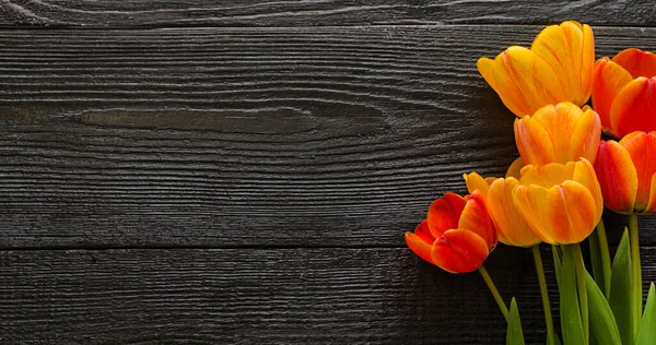 濃い黒の木の質感の背景に美しいチューリップの花 春の花束 フラットレイアウト トップビュー コピースペース — ストック写真