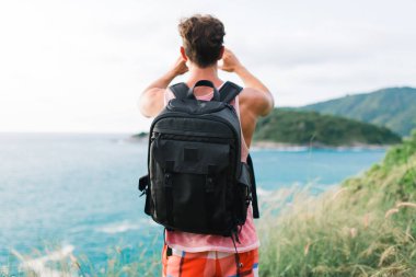 Bu görünümü daha daha güzel bir şey. Okyanus üzerinde görünümü bir resim çekmek sırt çantası ile genç adam 
