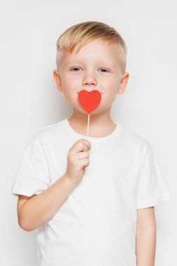  Dudakları karşı bir kalp şekli işaret tutan şirin küçük çocuk