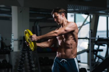 Spor salonunda ağırlık ile çalışma dışarı genç adam