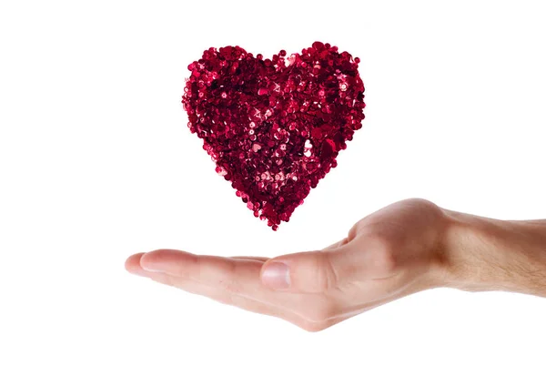 Hart gemaakt met rode sparkles op menselijke hand — Stockfoto