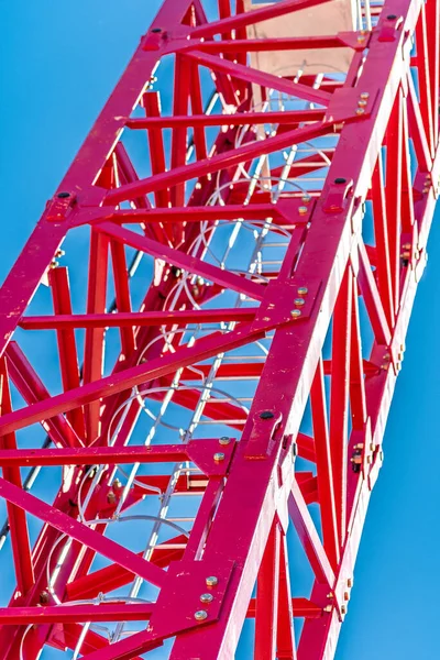 Věžový jeřáb, červený proti obloze a horám — Stock fotografie