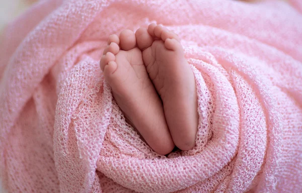 Közelről képet újszülött baba lábát egy rózsaszín kockás — Stock Fotó