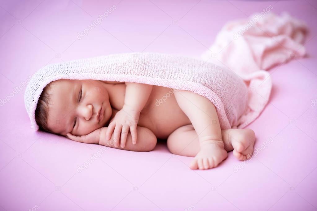 Newborn Baby Girl Sleeping Peacefully Under a Pink Blanket