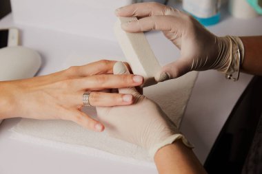 Kadın elleri güzellik salonunda manikür yaptırıyor. Tırnak törpüleme. Yaklaş, seçici odaklanma.