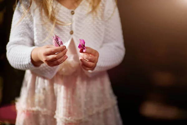 Закройте детали рук маленьких девочек, играющих с маленьким цветком — стоковое фото