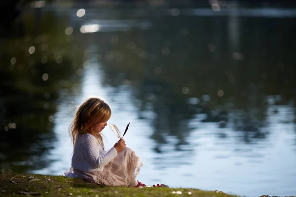 Niña jugando en la orilla del río — Foto de Stock