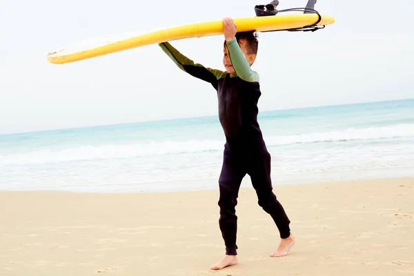 Junge Surfer kommt aus dem Wasser — Stockfoto