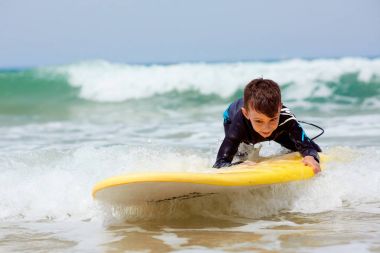 Genç çocuk çocuk Surfboard ile Yüzme