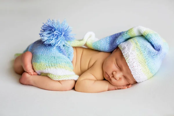 在针织帽子和内裤睡觉的可爱新生婴儿蜷缩着，顶视图 — 图库照片