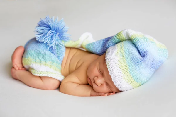 Precioso bebé recién nacido en sombrero de punto y bragas duerme acurrucado, vista superior —  Fotos de Stock