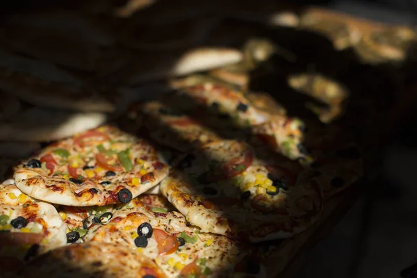 Dilimleri lezzetli taze mantar ve pizza biberli karanlık bir arka plan üzerinde kesmek. Üstten Görünüm. Boşaltmak. Pizza siyah masada.