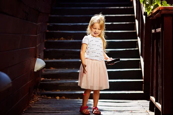 Blondýnka na dřevěné schodiště, užívat si letní dovolenou — Stock fotografie