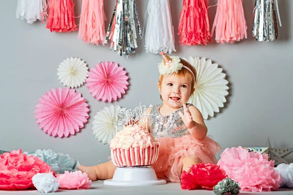 Little baby girl eating birthday cake during cake smash party — Stock Photo, Image